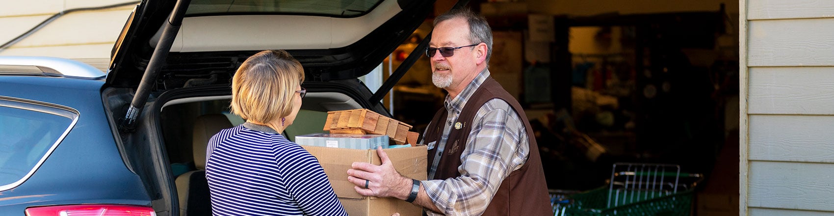 Man helping woman to load up her car.